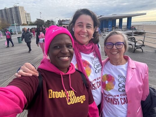 Faculty from Health and Nutrition Sciences Lisa Millsaps-Graham (left) and Margrethe Horlyck-Romanovsky (right) join Ana Bartolomé, operations manager and community outreach coordinator for the Brooklyn College Cancer Center, during the Breast Cancer Walk on the Coney Island Boardwalk.