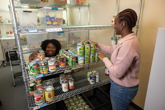 Brooklyn College student Ylé Blackburn and 2024 Rhema Mills, a CUNYCAP student employed in the Food Pantry who is currently attending the CUNY School of Public Health.
