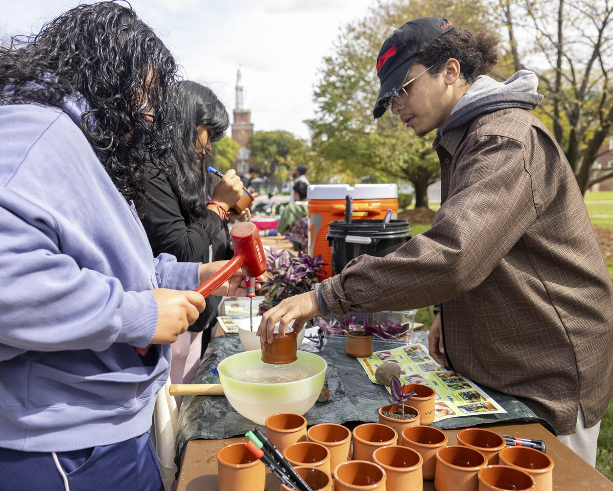 During the Sustainability Showcase, student ambassador Samuel Medrano De La Cruz (right) upcycling ceramic yogurt cups as planters. 