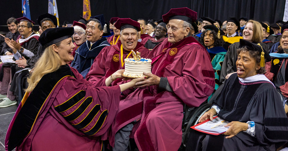 Brooklyn College President Michelle J. Anderson presents Leonard Tow ‘50, Brooklyn College Foundation Trustee and founder and chairman of The Tow Foundation, with a birthday cake as Evan Silverstein ‘76 (left) and Tania León look on.